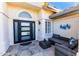 Cozy front porch featuring a modern black framed glass door and comfortable outdoor seating area at 9032 E Larkspur Dr, Scottsdale, AZ 85260