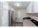 Laundry room with white cabinets, a sink, and a stainless steel refrigerator at 9032 E Larkspur Dr, Scottsdale, AZ 85260
