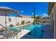 Resort-style pool features a tanning ledge, desert landscaping, and sunny skies at 9032 E Larkspur Dr, Scottsdale, AZ 85260