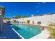 Sparkling pool features a tanning ledge, decorative planters, and ample patio space for relaxing in the sun at 9032 E Larkspur Dr, Scottsdale, AZ 85260