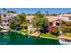 Exterior waterfront view of a home with a dock, lush landscaping and an inviting patio area at 10421 N 100Th St, Scottsdale, AZ 85258