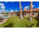 A grassy backyard with a pool and covered patio is surrounded by desert landscaping at 10563 E Bella Vista Dr, Scottsdale, AZ 85258