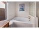 A bathtub with white tile surround is lit by a window and features glass block accents at 10563 E Bella Vista Dr, Scottsdale, AZ 85258