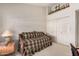 A sunlit bedroom features a wooden daybed with plaid bedding and a view from the window at 10563 E Bella Vista Dr, Scottsdale, AZ 85258