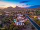 Desert home featuring a pool, spa, putting green, and lush landscaping all with the mountains in the background at 10707 E Cottontail Ln, Scottsdale, AZ 85255