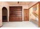 Empty den with built in shelves, an archway entrance and a doorway at 10707 E Cottontail Ln, Scottsdale, AZ 85255