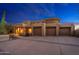 Exterior shot of a sprawling desert home with a four-car garage and desert landscaping at 10707 E Cottontail Ln, Scottsdale, AZ 85255