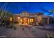 Inviting front entrance with desert landscaping, rock water feature, and accent lighting at 10707 E Cottontail Ln, Scottsdale, AZ 85255