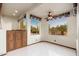 Bright living room with fan and two windows providing natural light and desert views at 10707 E Cottontail Ln, Scottsdale, AZ 85255