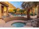 Inviting pool with mature palm trees, lush plants, waterfalls, and desert views at 10707 E Cottontail Ln, Scottsdale, AZ 85255