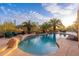 Serene pool with desert landscaping, rock accents, and comfortable seating, designed for ultimate relaxation and entertainment at 10707 E Cottontail Ln, Scottsdale, AZ 85255