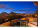 Rooftop terrace with outdoor seating and panoramic city and mountain views at twilight at 10707 E Cottontail Ln, Scottsdale, AZ 85255