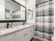 Well-lit bathroom featuring dual sinks, granite countertops, and decorative shower curtain at 11352 E Starkey Ave, Mesa, AZ 85212