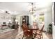 Dining room with a stylish light fixture, a wood table, and access to the living room at 11352 E Starkey Ave, Mesa, AZ 85212