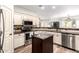 Well-lit kitchen featuring stainless steel appliances, a kitchen island, and ample countertop space at 11352 E Starkey Ave, Mesa, AZ 85212