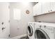 Bright laundry room with modern washer and dryer, and white cabinets for storage at 11352 E Starkey Ave, Mesa, AZ 85212