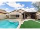 This backyard features a large swimming pool, covered patio, grassy area and privacy walls at 11831 W Daley Ct, Sun City, AZ 85373