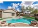 This backyard features a large swimming pool, covered patio, grassy area and privacy walls at 11831 W Daley Ct, Sun City, AZ 85373