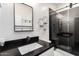 This bathroom features a framed mirror, geometric wall decor and a glass enclosed shower at 11831 W Daley Ct, Sun City, AZ 85373