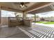 This covered patio features two stainless steel grills, a serving bar and views of the fireplace at 11831 W Daley Ct, Sun City, AZ 85373