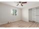 Bright bedroom with wood-look floors, closet with shelves, and natural light from the window at 1201 S 80Th St, Mesa, AZ 85209