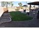 Lush backyard with manicured lawn, landscaping, and an outdoor kitchen area with shaded dining at 1353 S Western Skies Dr, Gilbert, AZ 85296