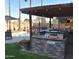 Stunning backyard with a covered kitchen, built-in grill, bar seating, and a view of the pool at 1353 S Western Skies Dr, Gilbert, AZ 85296