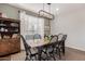 Inviting dining room with a wood table, black chairs, a modern light fixture, and a decorative cabinet at 1548 W Windhaven Ave, Gilbert, AZ 85233