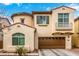 Charming two-story home features a brown two-car garage, stucco facade, and a delightful wrought-iron balcony at 1548 W Windhaven Ave, Gilbert, AZ 85233