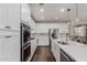 Well-lit kitchen showcasing white cabinets, stainless steel appliances, a kitchen island, and dark wood flooring at 1548 W Windhaven Ave, Gilbert, AZ 85233