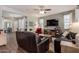 Spacious living room features neutral walls, dark leather couches, decorative rug, and a ceiling fan at 1548 W Windhaven Ave, Gilbert, AZ 85233