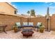 Cozy outdoor patio featuring a fire pit, seating, and a brick privacy wall, perfect for relaxing and entertaining at 1548 W Windhaven Ave, Gilbert, AZ 85233