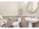 Charming powder room featuring wainscoting, a pedestal sink, an oval mirror, and neutral decor at 1548 W Windhaven Ave, Gilbert, AZ 85233