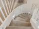 Curving staircase with neutral carpet, white railing, and wall lighting at 1548 W Windhaven Ave, Gilbert, AZ 85233