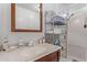 Charming bathroom featuring a sink with a wood-framed mirror and a decorative metal shelving unit at 17200 W Bell Rd # 2125, Surprise, AZ 85374