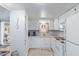 Bright kitchen featuring white appliances and cabinetry, complemented by floral curtains and ample counter space at 17200 W Bell Rd # 2125, Surprise, AZ 85374