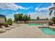 Community pool and spa area featuring lounge chairs, lush trees, and clear blue water, perfect for relaxation at 17200 W Bell Rd # 2125, Surprise, AZ 85374