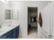Bathroom with double sinks, blue cabinets, mirror, and walk-in closet at 1978 E Connemara Dr, San Tan Valley, AZ 85140