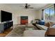 Cozy living room with hardwood floors, a ceiling fan, an aquarium, and a large window at 1978 E Connemara Dr, San Tan Valley, AZ 85140