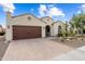 Well-maintained single-story home with desert landscaping, a two-car garage, and an inviting entrance at 21854 N 263Rd Dr, Buckeye, AZ 85396