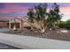 Attractive single-story home with manicured desert landscaping, mature trees, and inviting curb appeal at 21854 N 263Rd Dr, Buckeye, AZ 85396