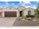 Inviting single-story home features desert landscaping, a two-car garage, and an arched entryway at 21854 N 263Rd Dr, Buckeye, AZ 85396