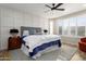 A beautifully decorated main bedroom with stylish furnishings and a ceiling fan at 21854 N 263Rd Dr, Buckeye, AZ 85396