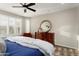 A bright main bedroom with white shutters, dresser with mirror, and a ceiling fan at 21854 N 263Rd Dr, Buckeye, AZ 85396