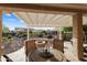 Inviting covered patio with dining set, fire pit, and desert landscaping, perfect for outdoor entertaining at 21854 N 263Rd Dr, Buckeye, AZ 85396