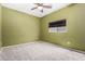 Carpeted room with olive green walls, ceiling fan, and a bright window at 219 E Valley View Dr, Phoenix, AZ 85042