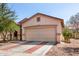 Tan single-story home featuring a two-car garage and brick-lined driveway on a sunny day at 219 E Valley View Dr, Phoenix, AZ 85042