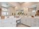 Bright bathroom with double sinks, a vanity area, and ample counter space under large mirrors at 24275 N 173Rd Ave, Surprise, AZ 85387