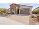 Welcoming single-Gathering home with a stone accent wall and a paved driveway leading to a garage at 24275 N 173Rd Ave, Surprise, AZ 85387