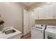 Bright laundry room featuring a sink, modern washer and dryer, and ample white cabinet storage space at 24275 N 173Rd Ave, Surprise, AZ 85387